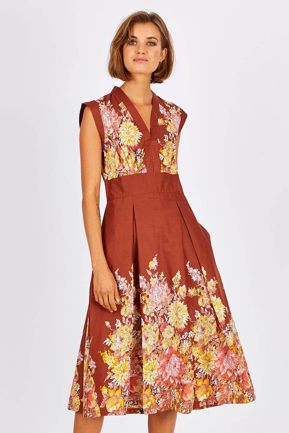 Model Nikki wearing size S of the Stephanie Dress in colour Anise, from the front, cropped image