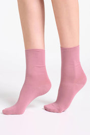 A model wearing the Comfort Top Sock in colour Rosewood (Pink), from the front, cropped image