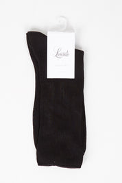 A model wearing size OneSize of the Rib Midi Sock in colour Nero (Black), from the front, showing the whole outfit