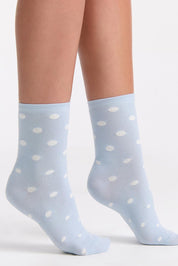 A model wearing the Gigi Spot Sock in colour Capri (Blue), from the front, cropped image