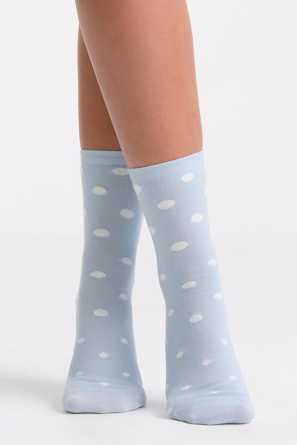 A model wearing the Gigi Spot Sock in colour Capri (Blue), from the front, cropped image