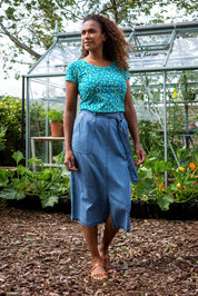 A model wearing the Cowslip Skirt in colour Denim (Blue), from the front, showing the whole outfit