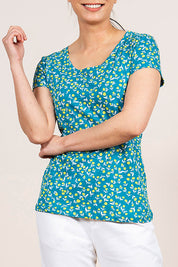 A model wearing the Cockles Tee in colour Teal (Blue), from the front, cropped image