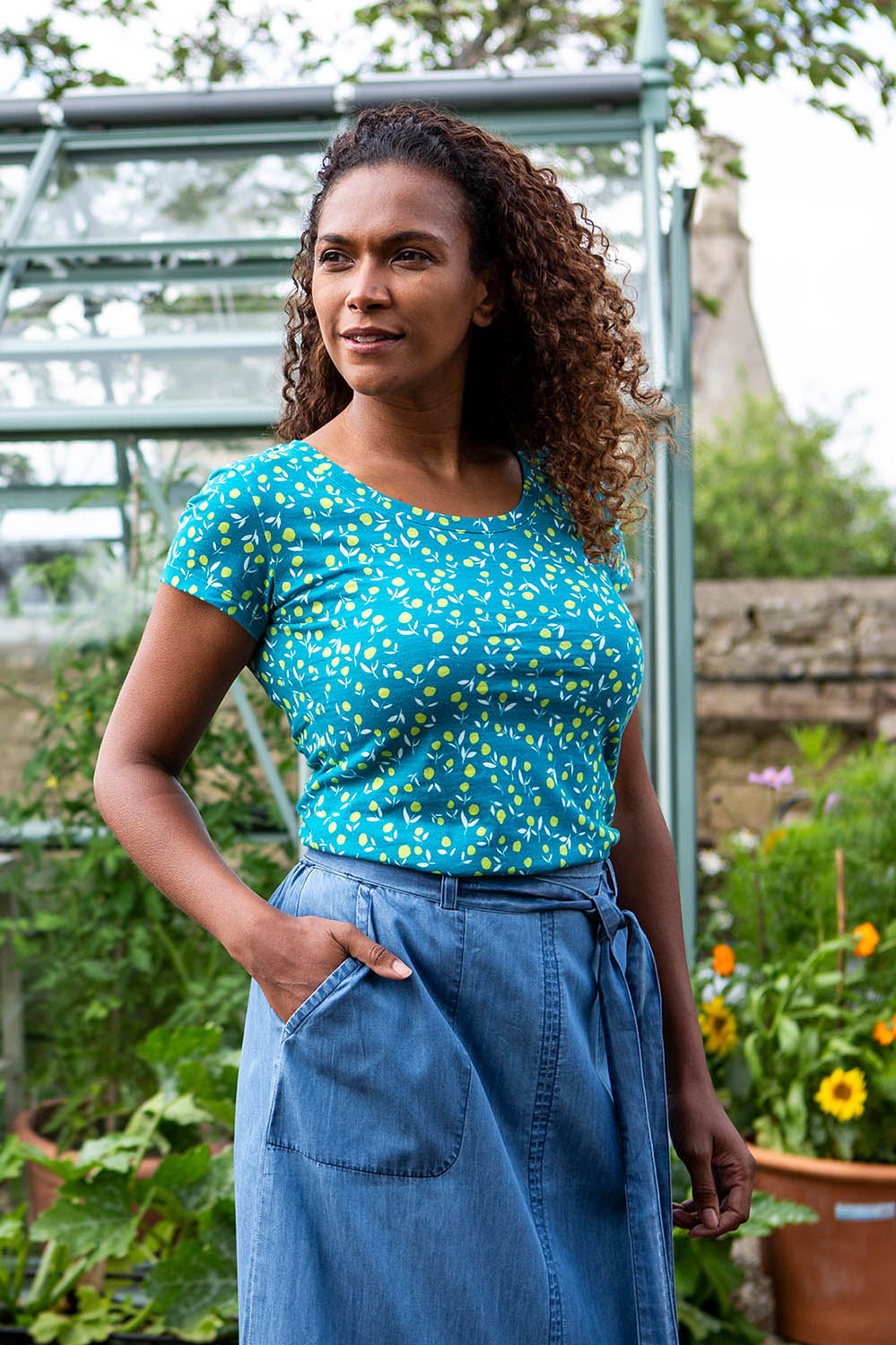 A model wearing the Cockles Tee in colour Teal (Blue), from the front, showing the whole outfit
