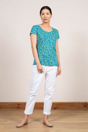 A model wearing the Cockles Tee in colour Teal (Blue), from the front, showing the whole outfit