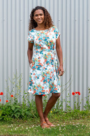 A model wearing the Seren Dress in colour White (White), from the front, showing the whole outfit