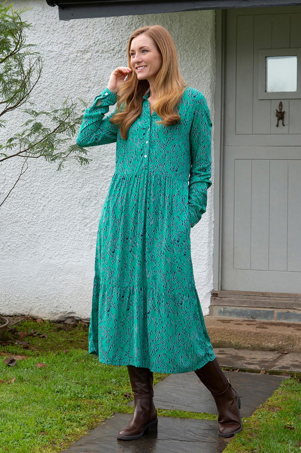 A model wearing the Valley Dress in colour Green (Green), from the front, showing the whole outfit