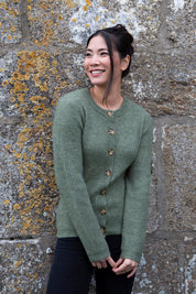 A model wearing the Cosy Cardi in colour Khaki (Green), from the front, showing the whole outfit