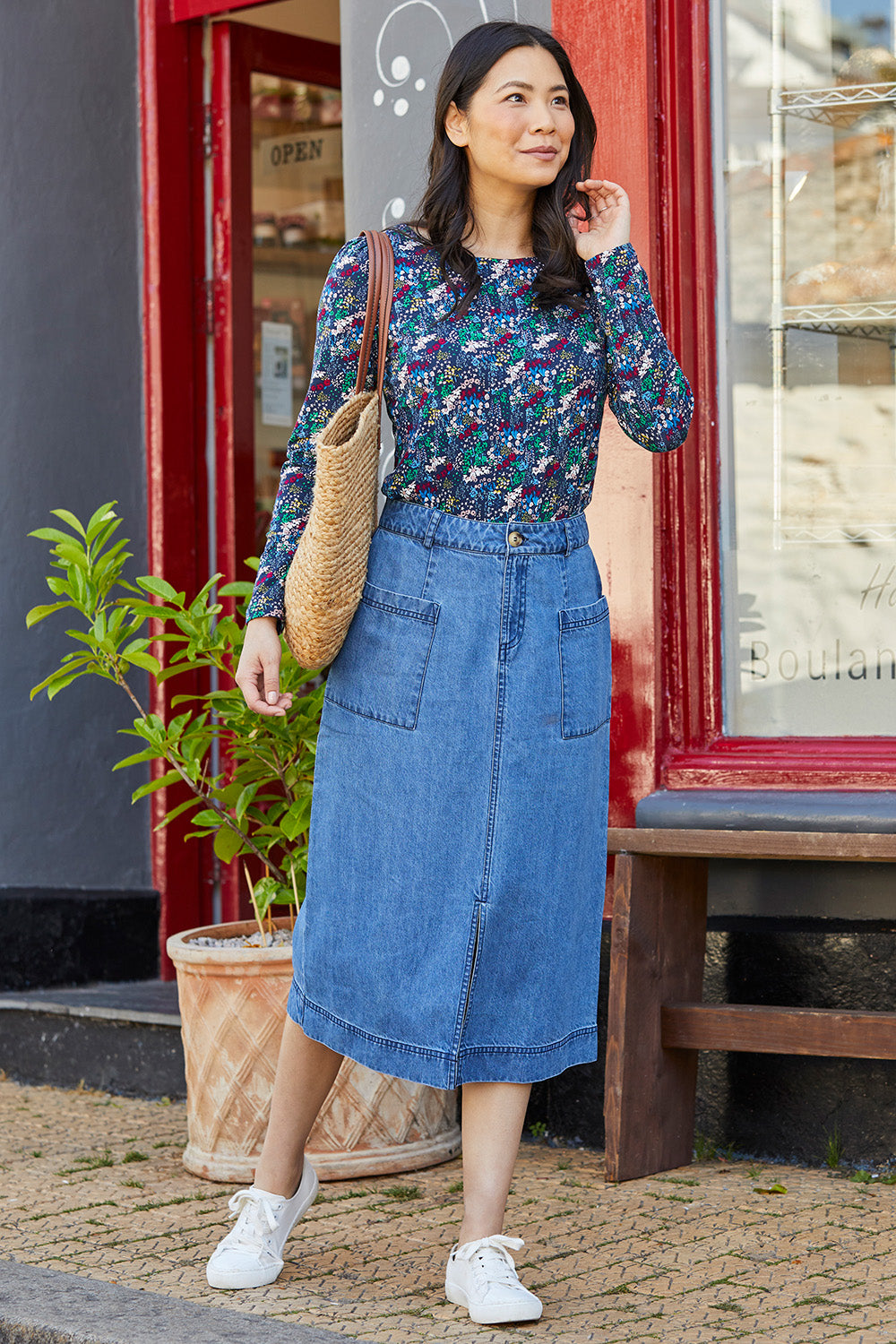 A model wearing the Penrose Skirt in colour Denim (Blue), from the front, showing the whole outfit
