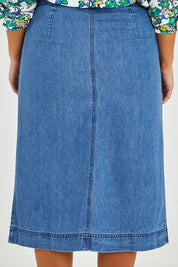 Model Monique wearing size 14 of the Penrose Skirt in colour Denim (Blue), from the back