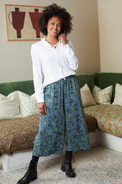 A model wearing the Elouise Trouser in colour Navy (Blue), from the front, showing the whole outfit