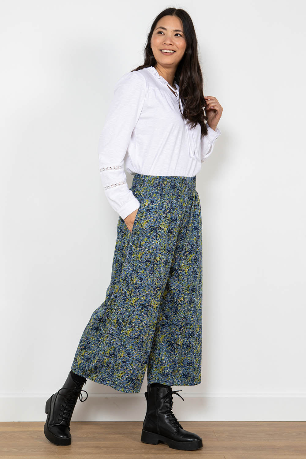 A model wearing the Elouise Trouser in colour Navy (Blue), from the front, showing the whole outfit