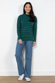 A model wearing the Oaksey Trouser in colour Denim (Blue), from the front, showing the whole outfit