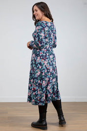 A model wearing the Jersey Swing Dress in colour Folkfloral (Blue), from the back