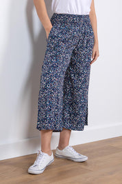 A model wearing the Evie Trouser in colour Navy (Blue), from the front, cropped image