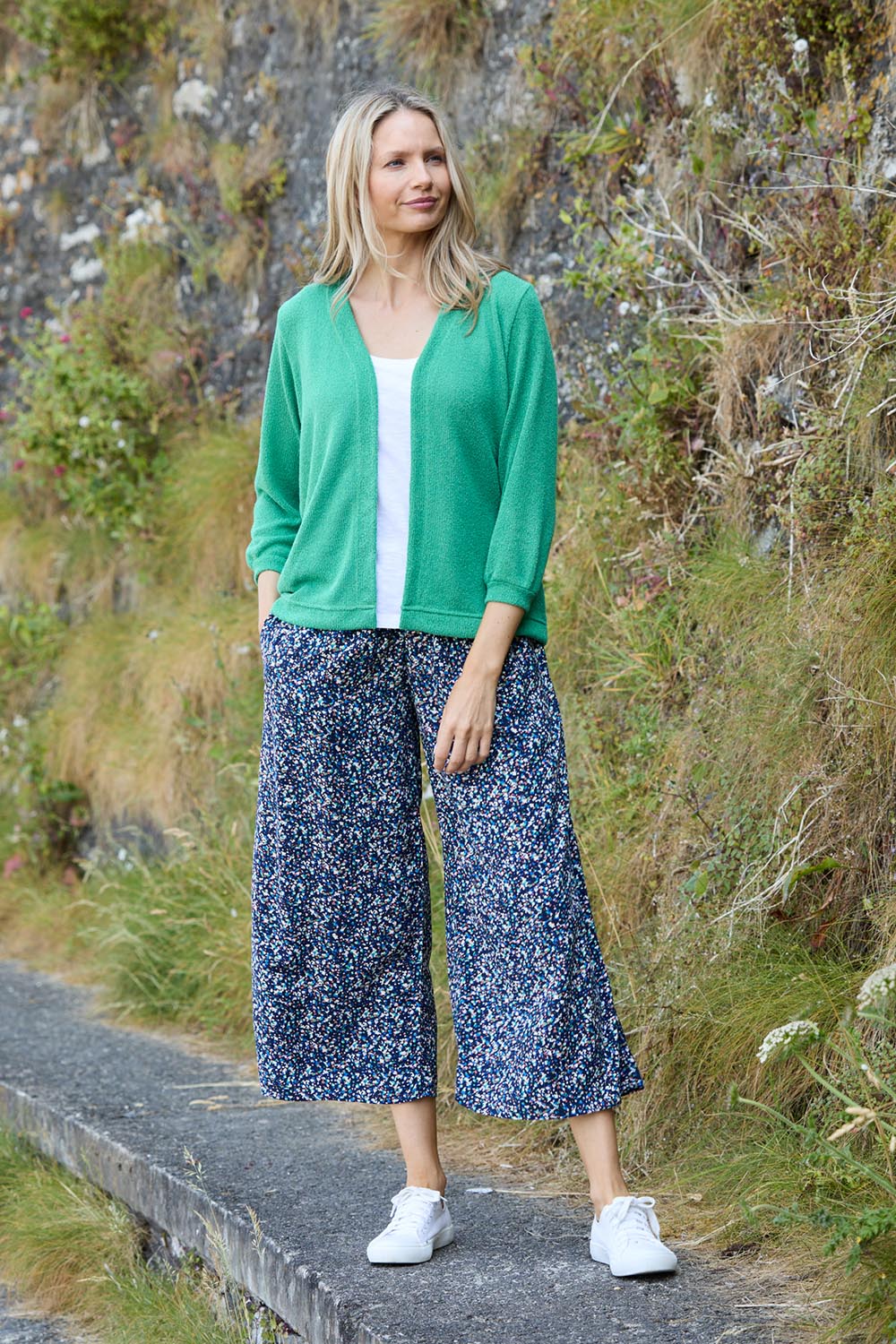 A model wearing the Evie Trouser in colour Navy (Blue), from the front, showing the whole outfit