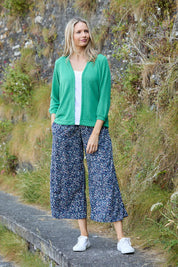 A model wearing the Evie Trouser in colour Navy (Blue), from the front, showing the whole outfit