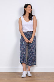 A model wearing the Evie Trouser in colour Navy (Blue), from the front, showing the whole outfit