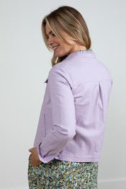 A model wearing the Clovelly Jacket in colour Lavender (Purple), from the back