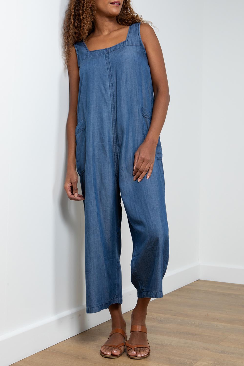 A model wearing the Edith Jumpsuit in colour Tencel (Blue), from the front, cropped image