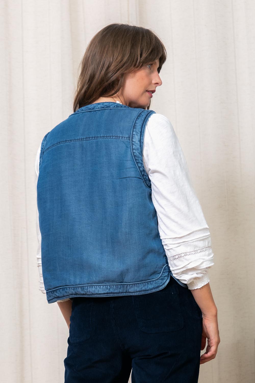 A model wearing the Deco Quilted Tencel Gilet in colour Blue (Blue), from the back