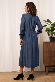 A model wearing the Christine Tencel Dress in colour Blue (Blue), from the back