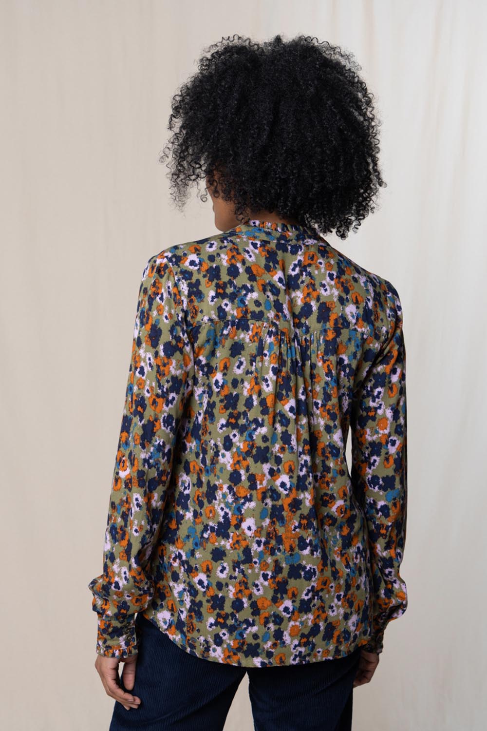 A model wearing the Rita Frill Shirt Floral Ikat in colour Olive (Green), from the back