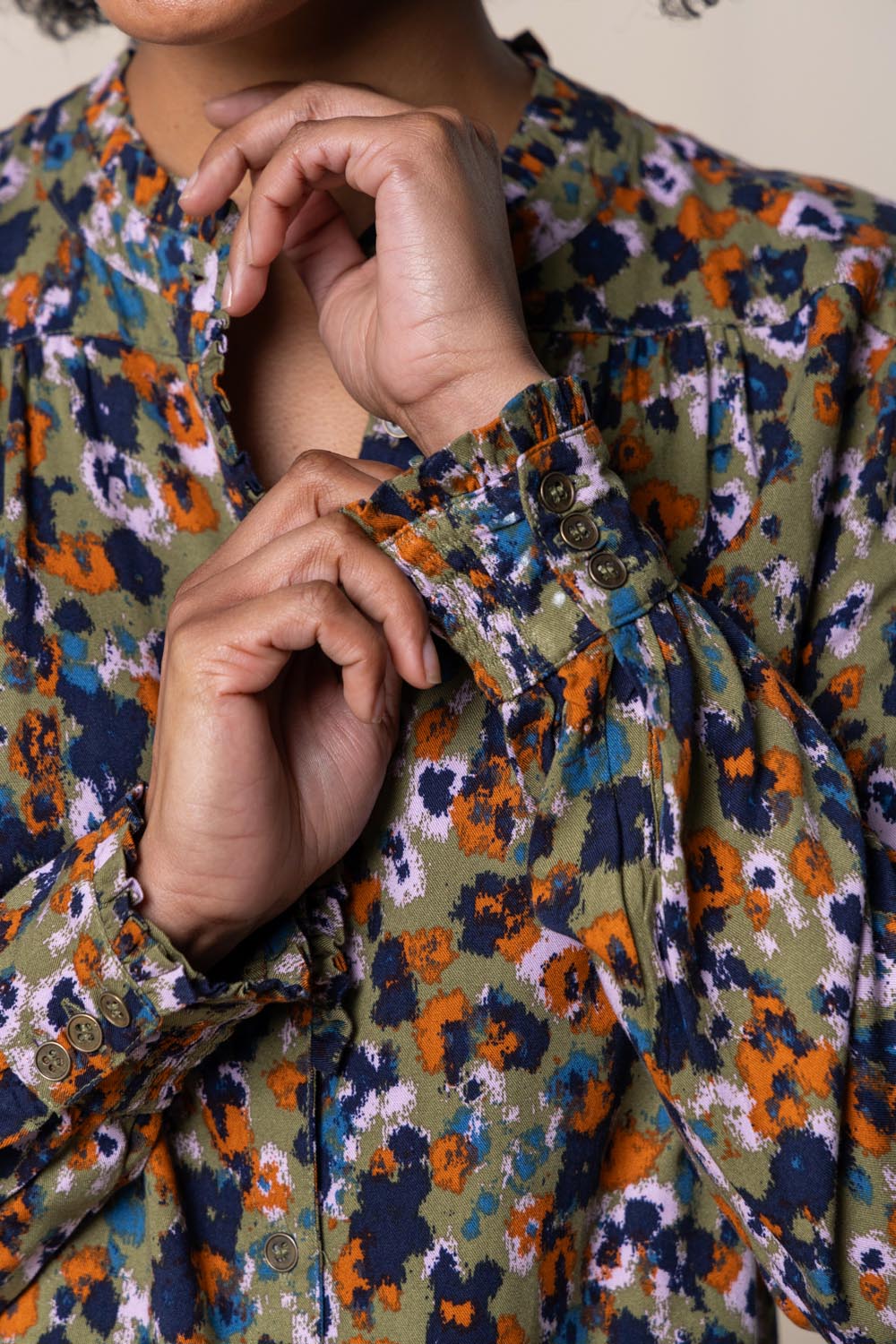 A model wearing the Rita Frill Shirt Floral Ikat in colour Olive (Green), from the front, cropped image