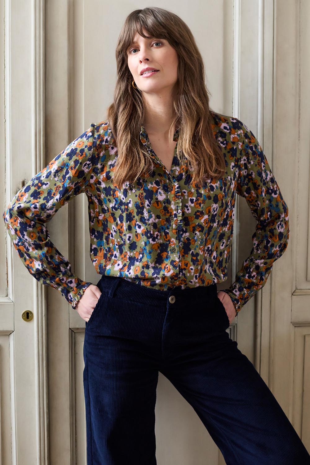 A model wearing the Rita Frill Shirt Floral Ikat in colour Olive (Green), from the front, showing the whole outfit