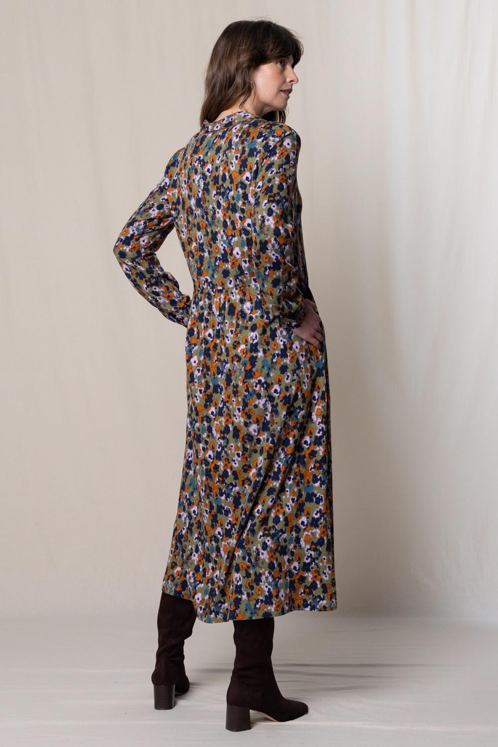 A model wearing the Seasons Dress in colour Olive (Green), from the back