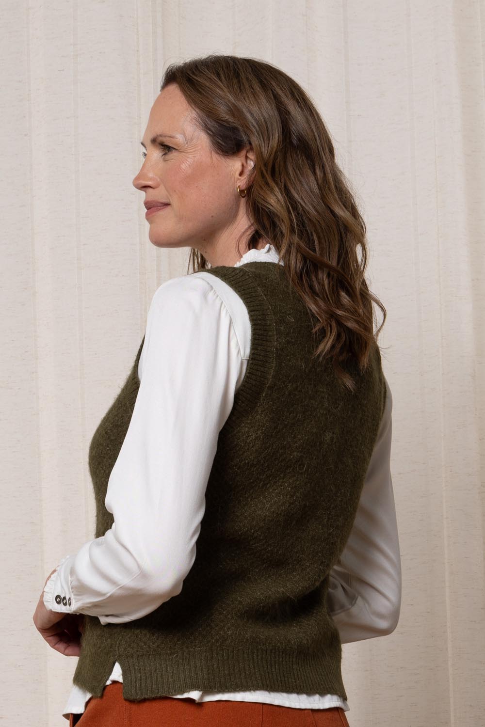 A model wearing the Laurel Tank in colour Olive (Green), from the back