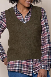 A model wearing the Laurel Tank in colour Olive (Green), from the front, cropped image