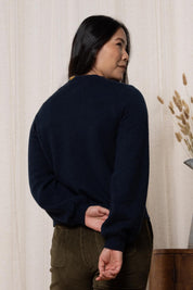 A model wearing the Helene Cardigan in colour Navy (Blue), from the back