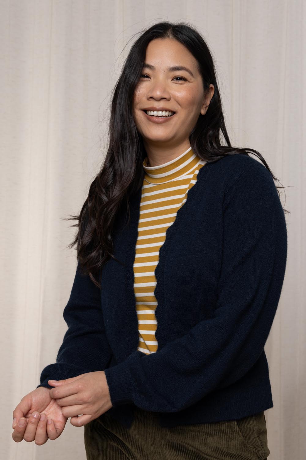 A model wearing the Helene Cardigan in colour Navy (Blue), from the front, cropped image