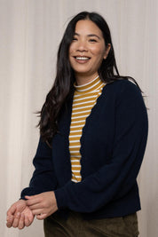 A model wearing the Helene Cardigan in colour Navy (Blue), from the front, cropped image