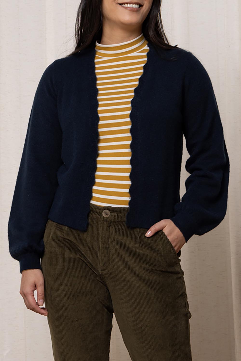 A model wearing the Helene Cardigan in colour Navy (Blue), from the front, cropped image
