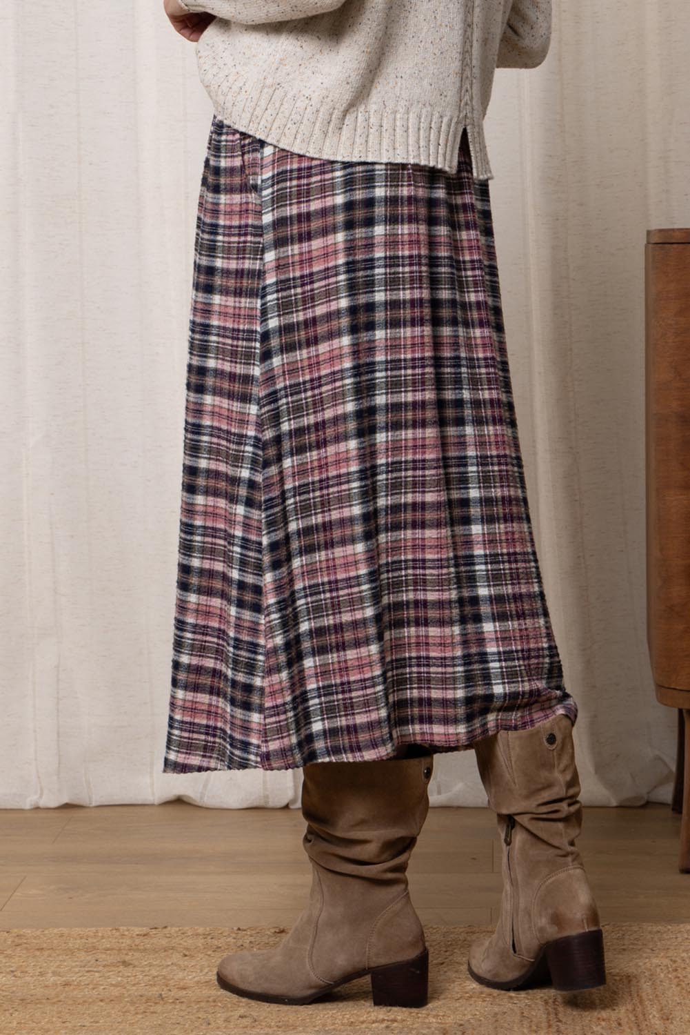 A model wearing the Alice Check Skirt in colour Mulberry (Red), from the back