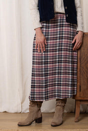 A model wearing the Alice Check Skirt in colour Mulberry (Red), from the front, cropped image