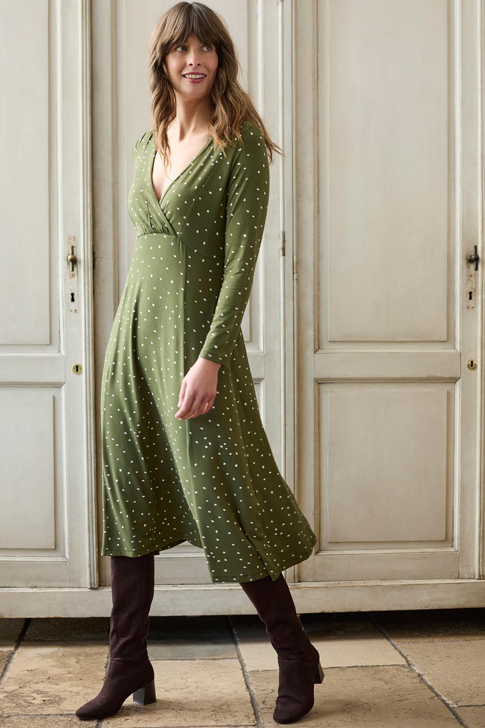 A model wearing the Rose Dress in colour Olive (Green), from the front, showing the whole outfit