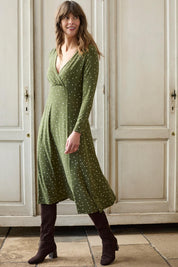 A model wearing the Rose Dress in colour Olive (Green), from the front, showing the whole outfit
