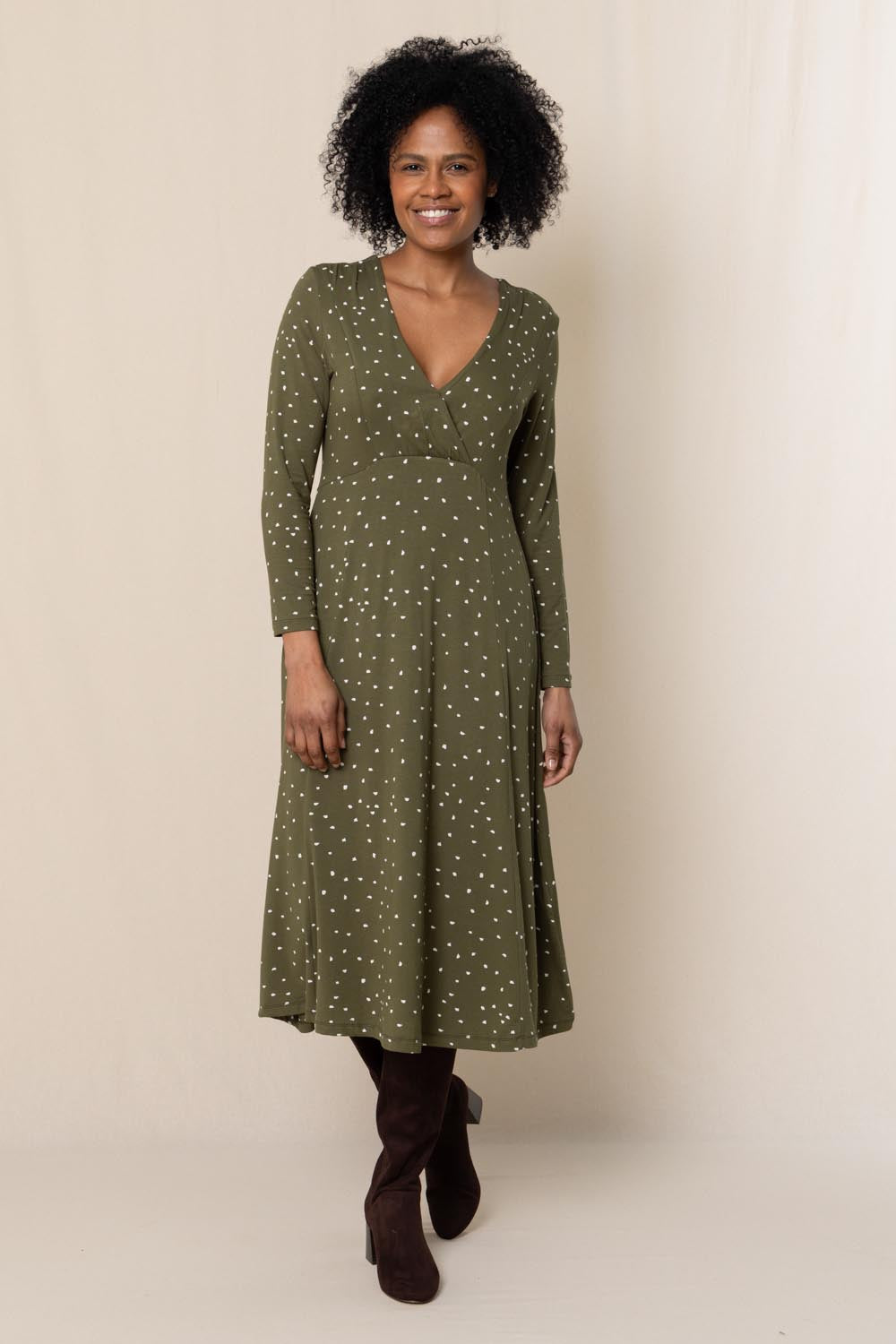 A model wearing the Rose Dress in colour Olive (Green), from the front, showing the whole outfit
