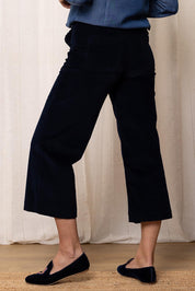 A model wearing the Isla Crop Cotton Cord Trouser in colour Navy (Blue), from the back