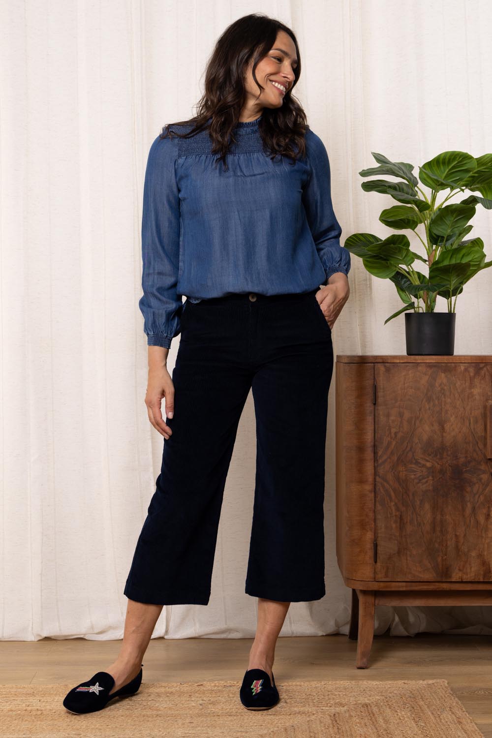 A model wearing the Isla Crop Cotton Cord Trouser in colour Navy (Blue), from the front, showing the whole outfit