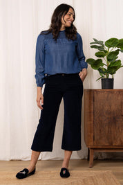 A model wearing the Isla Crop Cotton Cord Trouser in colour Navy (Blue), from the front, showing the whole outfit