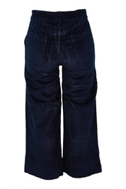 Product shot of the Isla Crop Cotton Cord Trouser in colour Navy (Blue), from the back