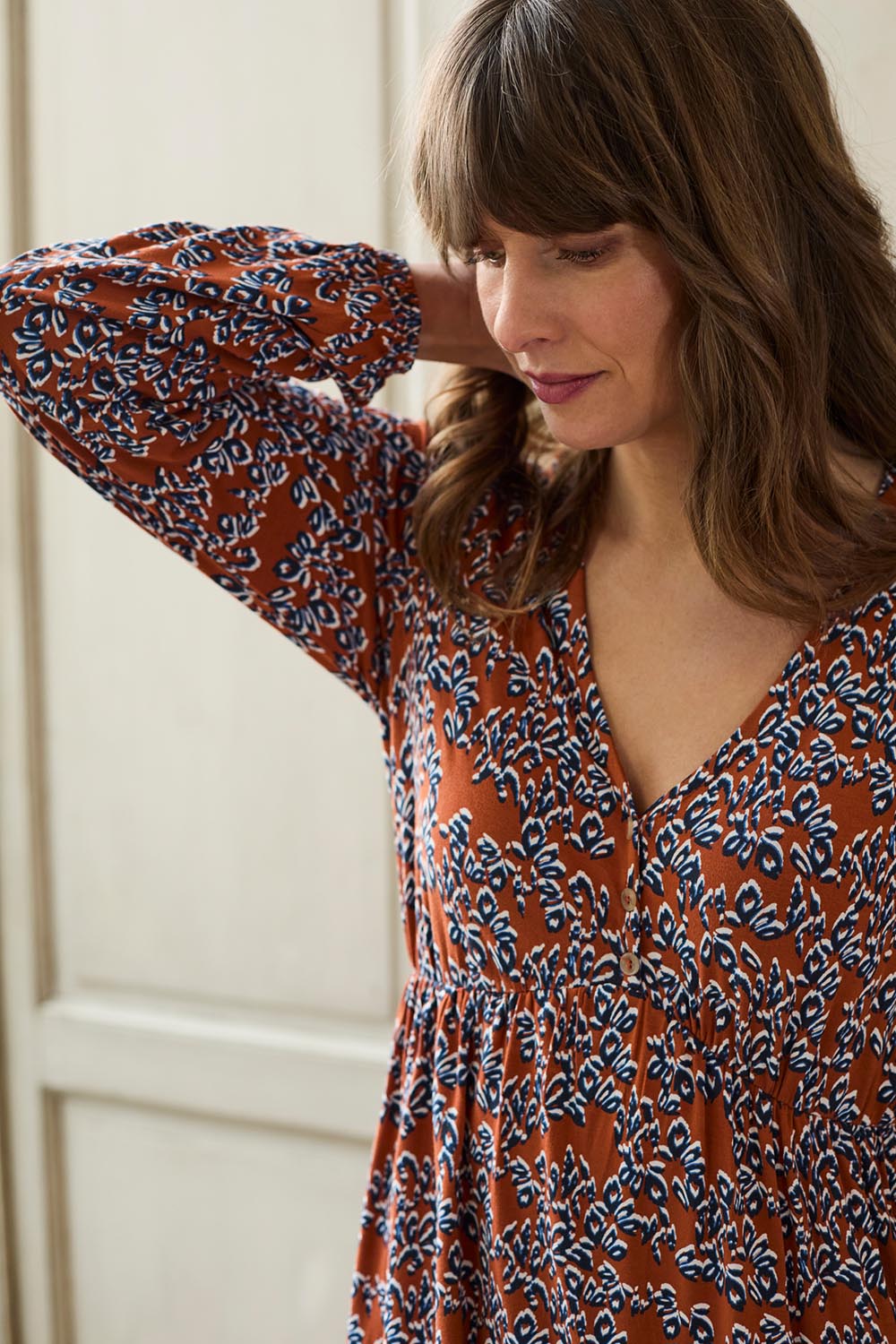 A model wearing the Lillian Dress Animal Stamp in colour Ginger, from the front, cropped image