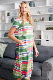 A model wearing the Summer Breeze Dress in colour Striaplgre (Green), from the front, showing the whole outfit