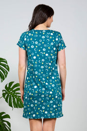 A model wearing the Heather Dress in colour Darkteal (Green), from the back