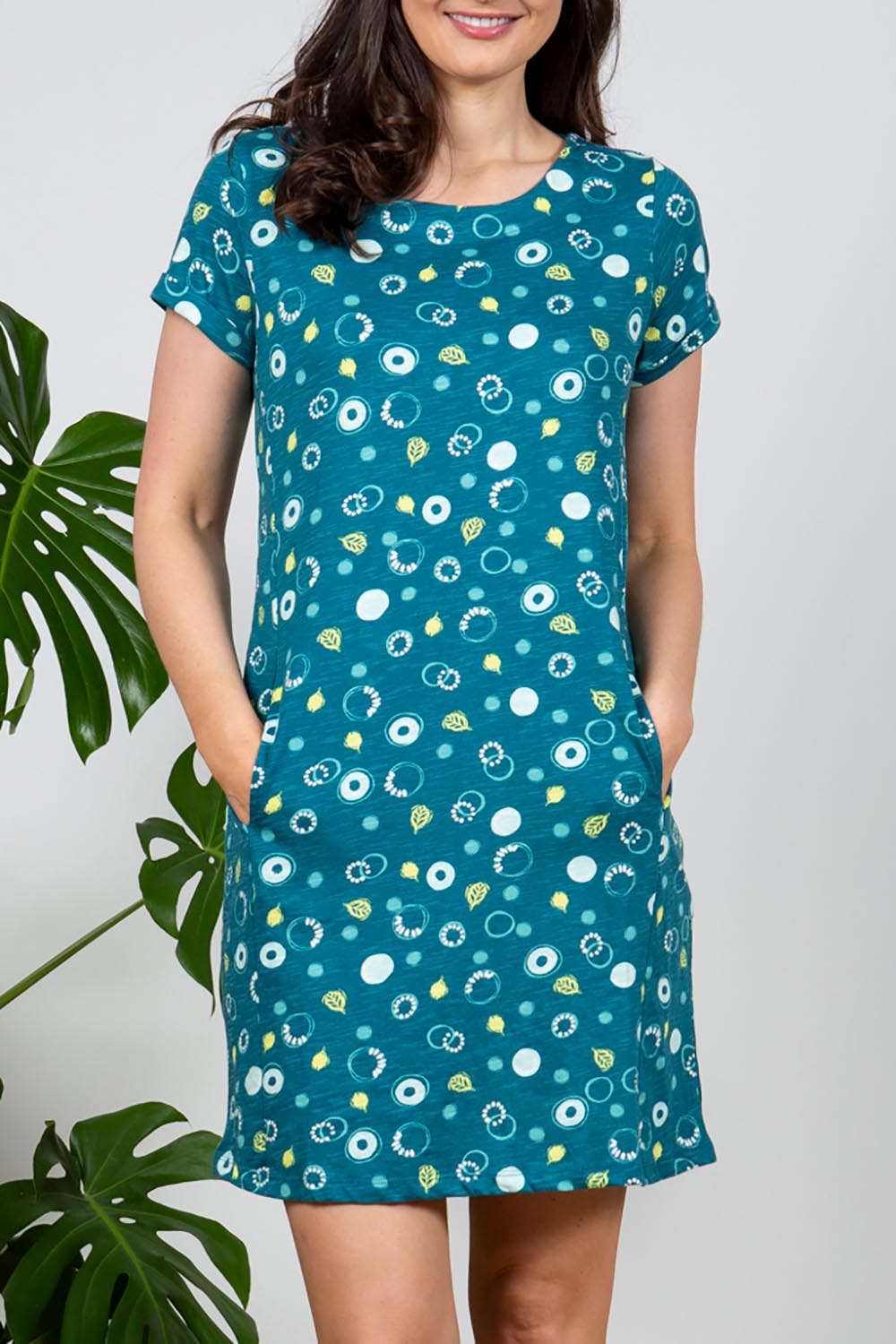 A model wearing the Heather Dress in colour Darkteal (Green), from the front, cropped image