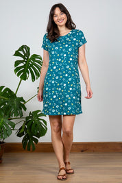 A model wearing the Heather Dress in colour Darkteal (Green), from the front, showing the whole outfit